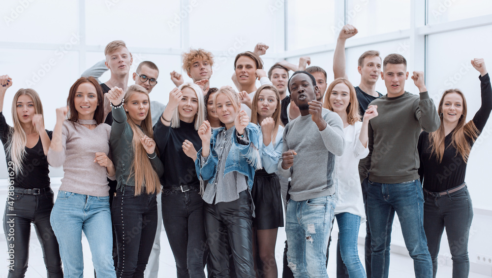 Obraz premium large group of happy young people showing their success