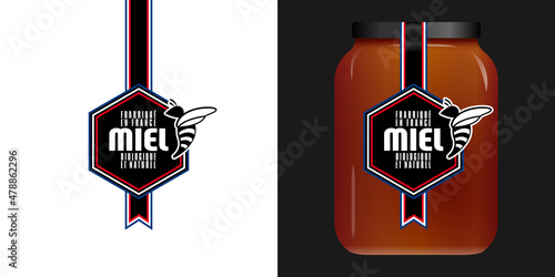Etiquette graphique noire et blanche avec un hexagone et une petite abeille pour un bocal de miel d’un producteur français - traduction : miel, fabriqué en France, biologique et naturel.