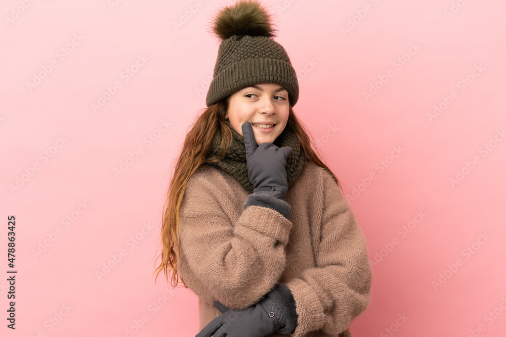 Little girl with winter hat isolated on pink background thinking an idea while looking up Little girl with winter hat isolated on pink background thinking an idea while looking up
