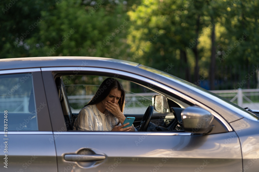 Girl cry reading message in mobile phone. Frustrated upset young woman in tears sit at driver seat in car with smartphone in hand. Female get bad news, breaking up with boyfriend in text sms messenger Girl cry reading message in mobile phone. Frustrated upset young woman in tears sit at driver seat in car with smartphone in hand. Female get bad news, breaking up with boyfriend in text sms messenger