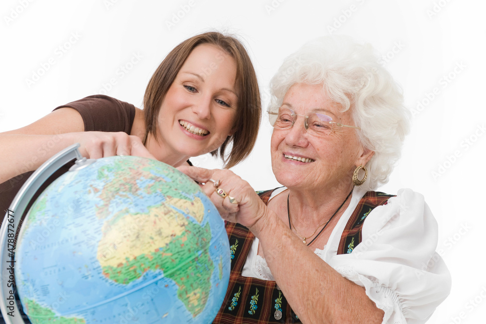 Junge Frau und Seniorin mit Globus Junge Frau und Seniorin mit Globus