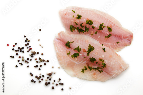 Prepared raw white fish fillet sprinkled with pink salt and herbs