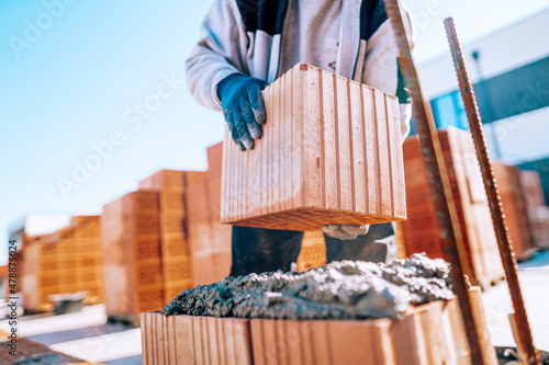 Foto industrial bricklayer installing bricks on construction site