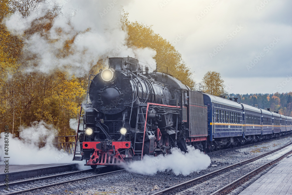 Obraz premium Retro steam train arrives to the station wooden platform. Ruskeala.