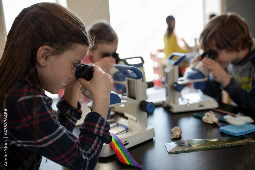 Students using microscopes in science laboratory classroom Stock Photo