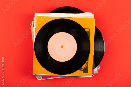 A stack of old vinyl records on a red background.Top view.