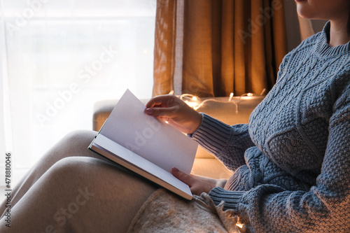 Young woman sitting on sofa...