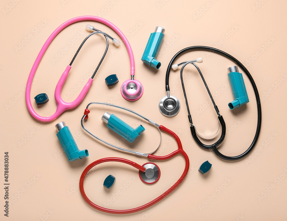 Asthma inhalers and stethoscopes on beige background Asthma inhalers and stethoscopes on beige background