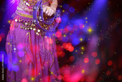 Belly Dancer wearing purple dance costume close up with bokeh