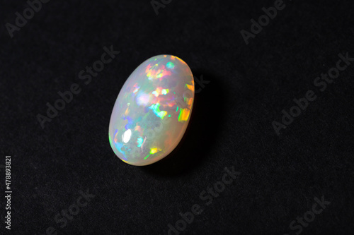 Colorful milky opal gem from Welo Ethiopia on black background photo