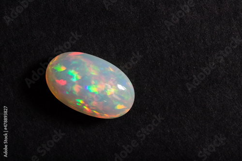 Colorful milky opal gem from Welo Ethiopia on black background