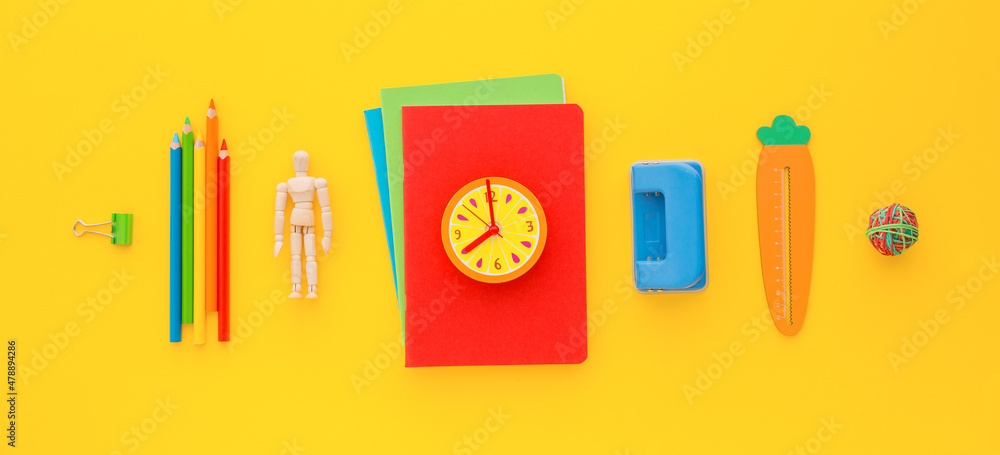 School supplies, notebooks, clips and pencils in a line. Yellow banner. School supplies, notebooks, clips and pencils in a line. Yellow banner.