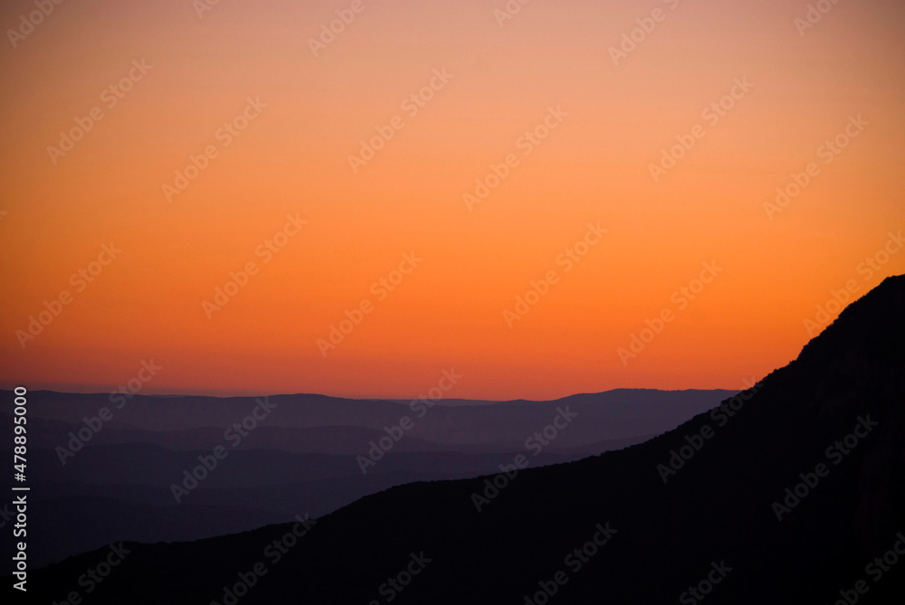 Obraz premium Foggy mountains silhouettes at morning sunrise