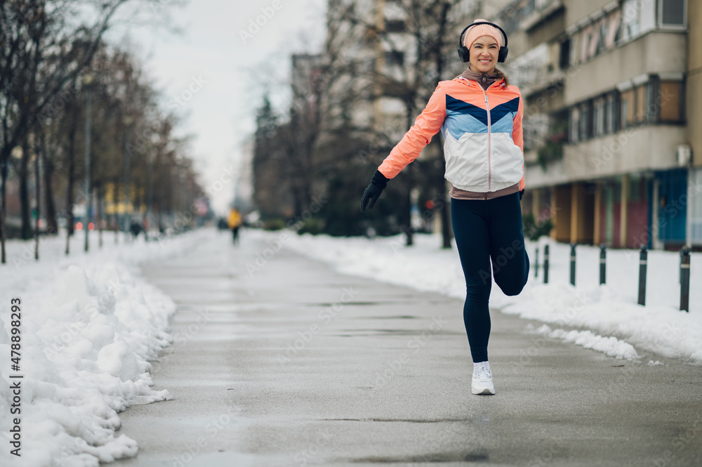 Woman does stretching before training in the snow in the winter. Woman does stretching before training in the snow in the winter.