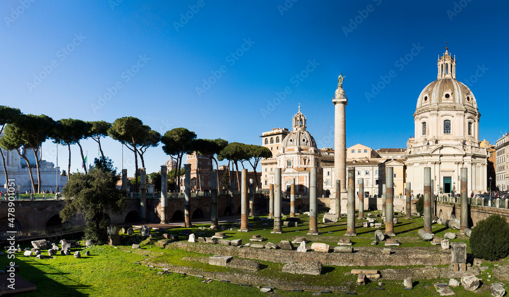 Wide angle view of the blue sky above the ancient ruins, Church of the Most Holy Name of Mary at the Trajan Forum and Trajan column in the morning light in Rome, Italy
