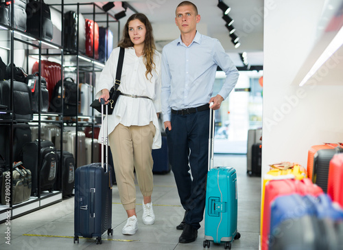 Married couple with suitcases in dry goods store photo