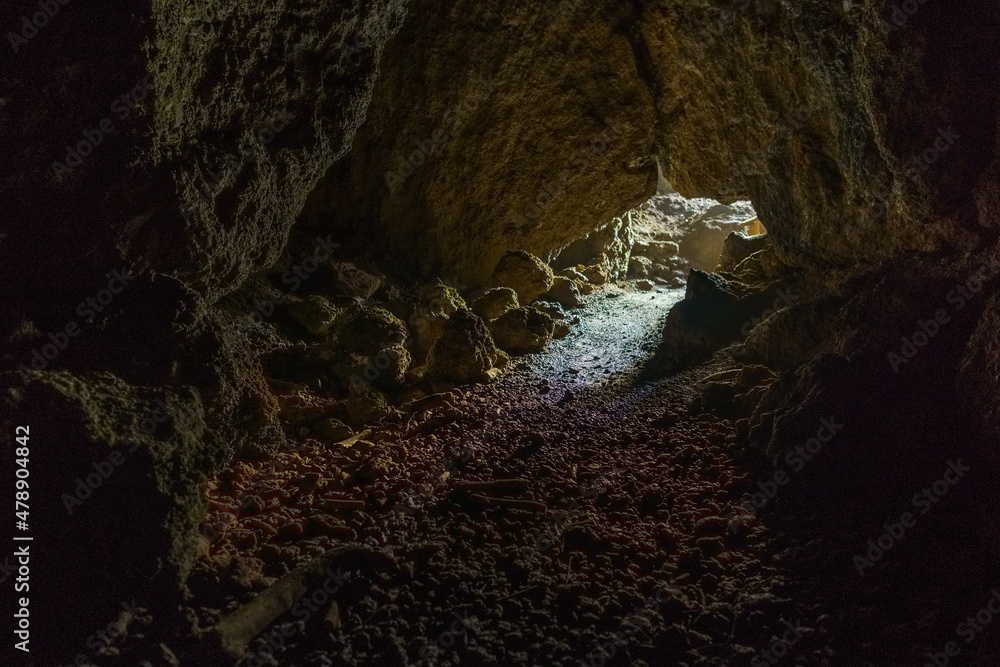 light falling through entrance of a cave falling on stone walls light falling through entrance of a cave falling on stone walls