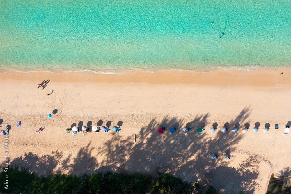 Aerial drone top view crowd of happy people relax at tropical Beach with sunset in Phuket, Thailand, Beautiful Phuket beach is famous tourist destination at Andaman sea. Holiday summer concept