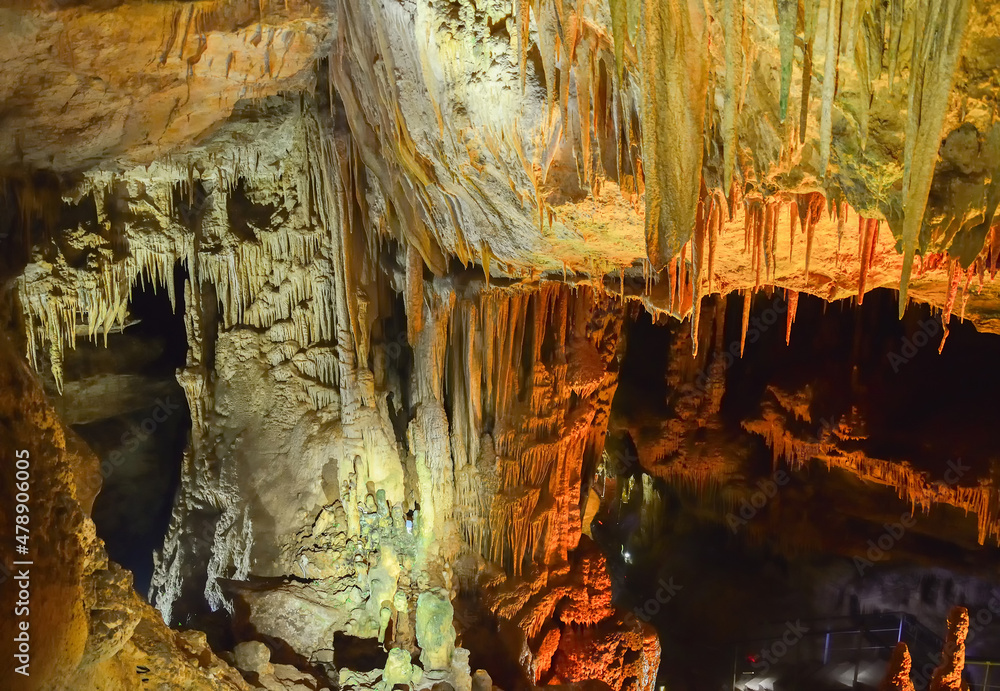 Prometheus cave formations in Georgia. Limestone stalactites and stalagmites in colourful illumination. Underground world of caucasian mountains