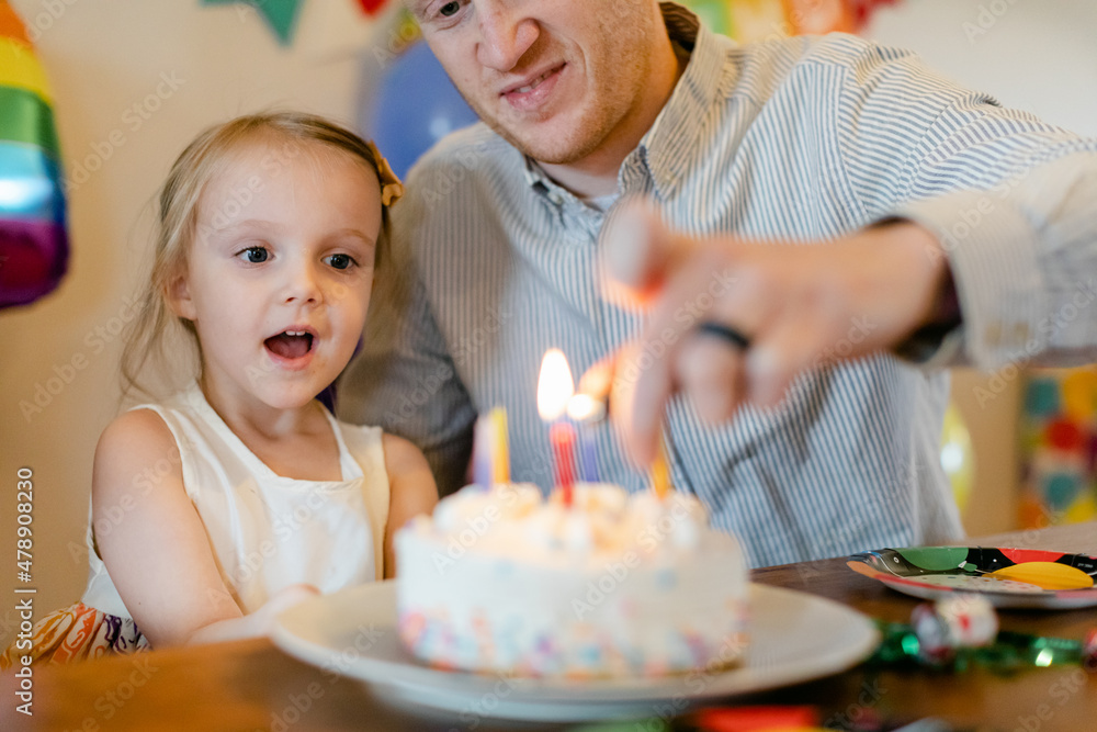 Dad Lights Candles on Child's Birthday Cake Dad Lights Candles on Child's Birthday Cake