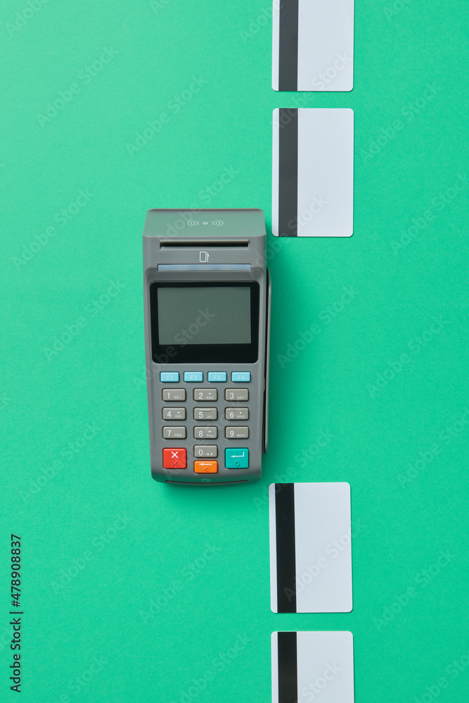 POS terminal and credit cards on green background POS terminal and credit cards on green background