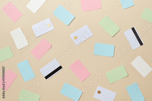 Colorful bank cards scattered on beige background