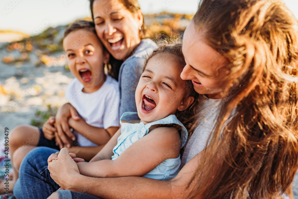 Laughing family with two moms at beach Laughing family with two moms at beach