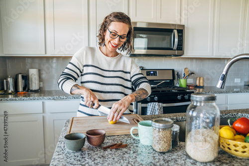 Happy woman slicing lemon in home kitchen photo