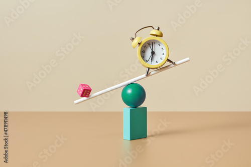 Dice and alarm clock balancing photo