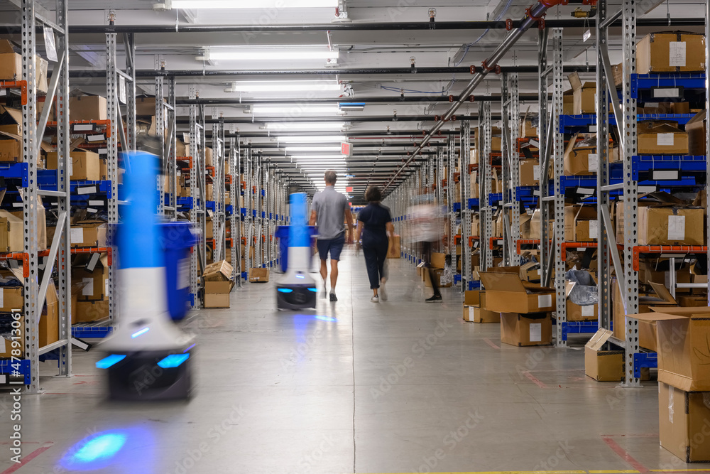 Robots and workers at Ecommerce Warehouse Robots and workers at Ecommerce Warehouse