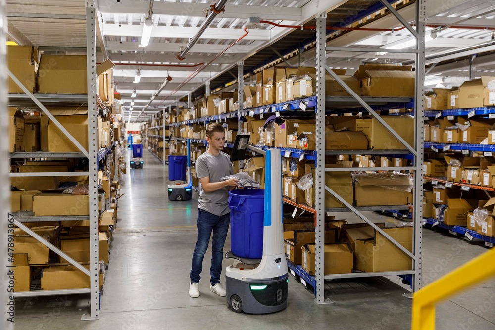 Worker with Robot at Warehouse E-Commerce site Worker with Robot at Warehouse E-Commerce site