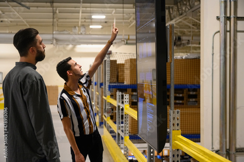 Hispanice employee looking at monitor at warehouse  photo