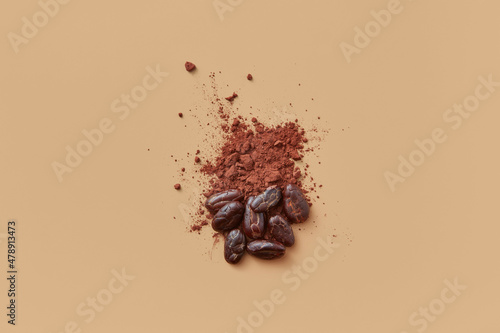 Cocoa powder and beans on beige background photo