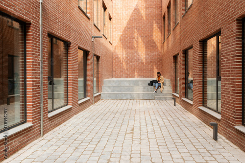 Girl with laptop in building alley