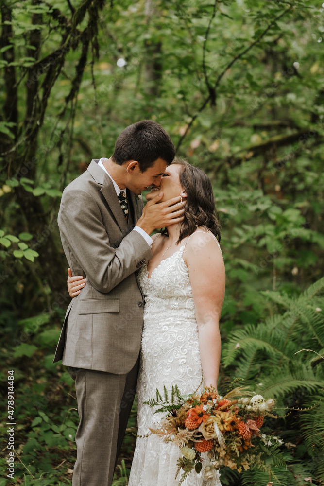 Smiling Couple Kiss While Standing in Forest Smiling Couple Kiss While Standing in Forest
