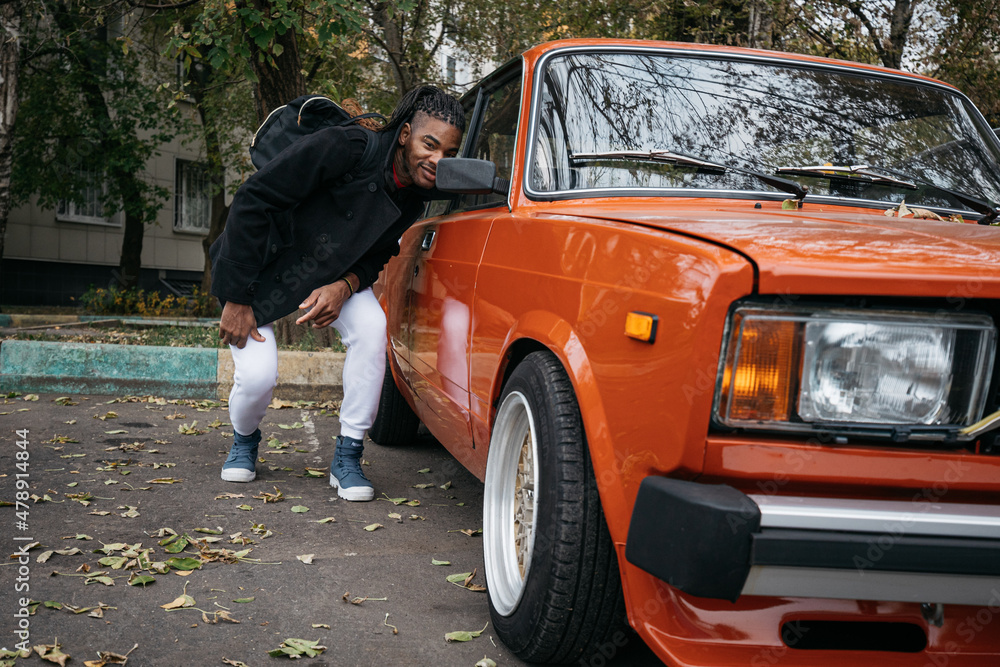 Back man with dreadlocks look at himself in car mirror Back man with dreadlocks look at himself in car mirror