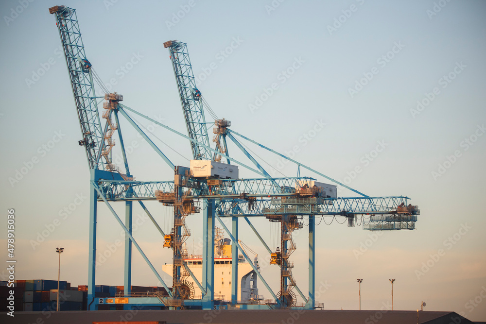 Crane and shipping containers against a sunset sky in Australia