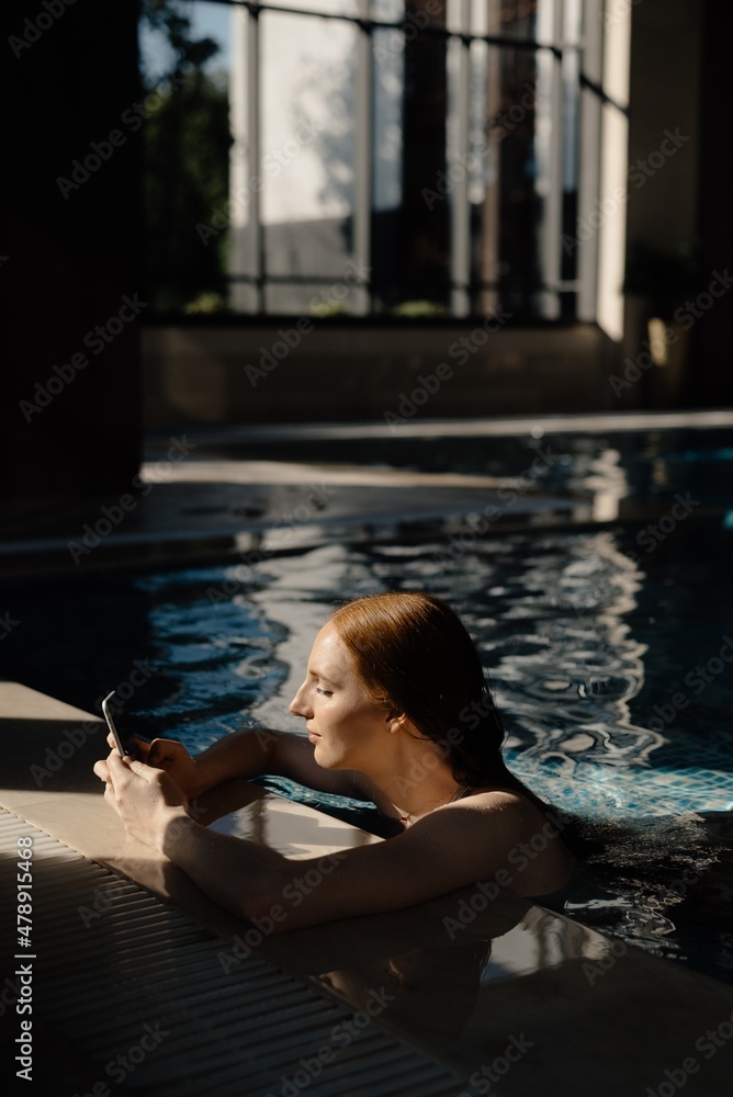 Young woman using smartphone in pool
Young woman using smartphone in pool