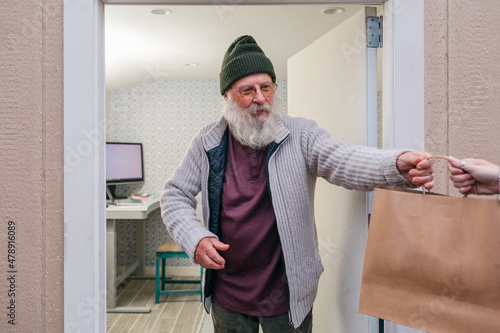 Elderly man picking up a home delivery photo