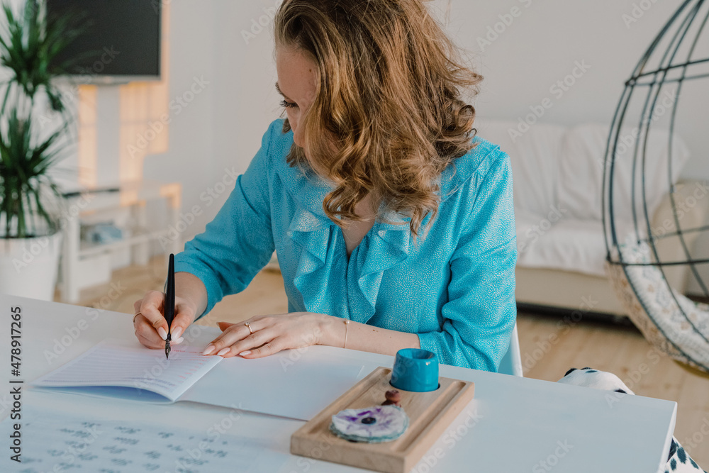 Woman practicing calligraphy with a dip pen Woman practicing calligraphy with a dip pen