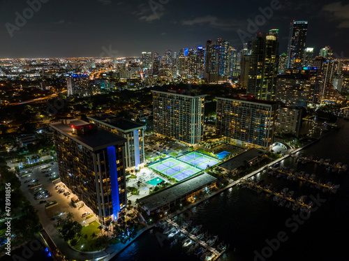 Night aerial photo residential buildings with lit tennis courts