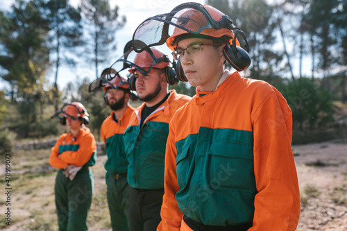 Group of lumberjacks in uniform in forest photo