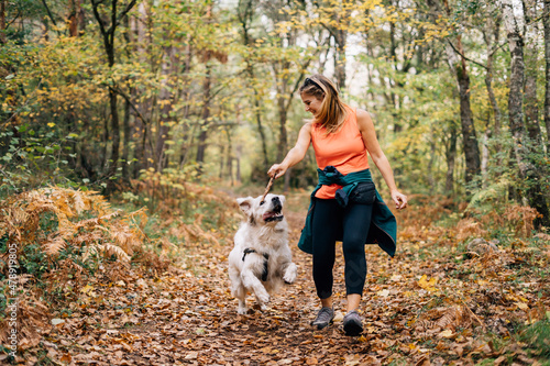 A beautiful woman has fun with her dog in autumn photo