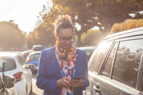 mature business woman using smartphone near her  car