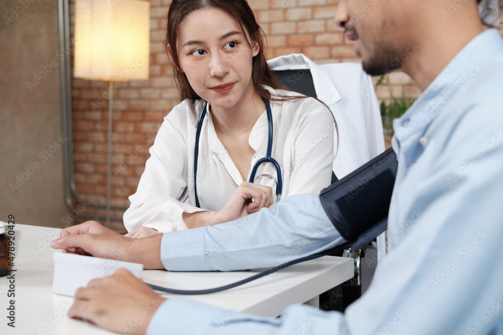 Fototapeta premium Beautiful woman doctor in white shirt who is Asian person with stethoscope is health examining male patient in brick wall background medical clinic, advising medical specialist occupation.