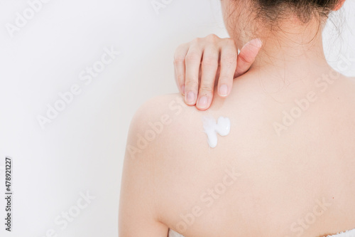 Woman applying cream,lotion on back with white background, Beauty concept.