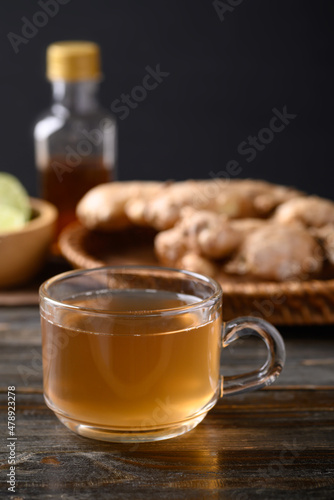 Ginger tea with lime and honey on wooden background, Healthy herbal drink