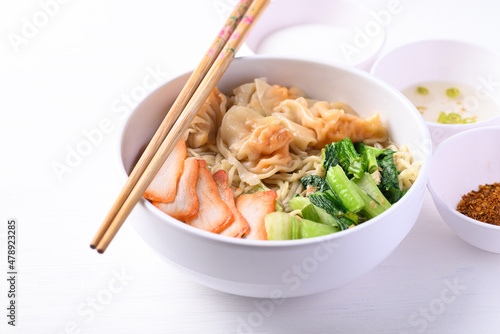 Noodles soup with wonton dumpling and grilled red pork in bowl on white background, Asian food