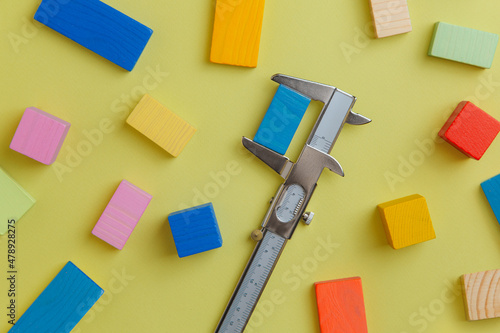 Wooden colourful blocks measured with a calliper photo