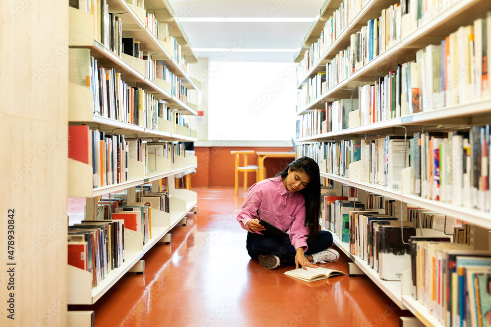 Woman reading on library floor Woman reading on library floor